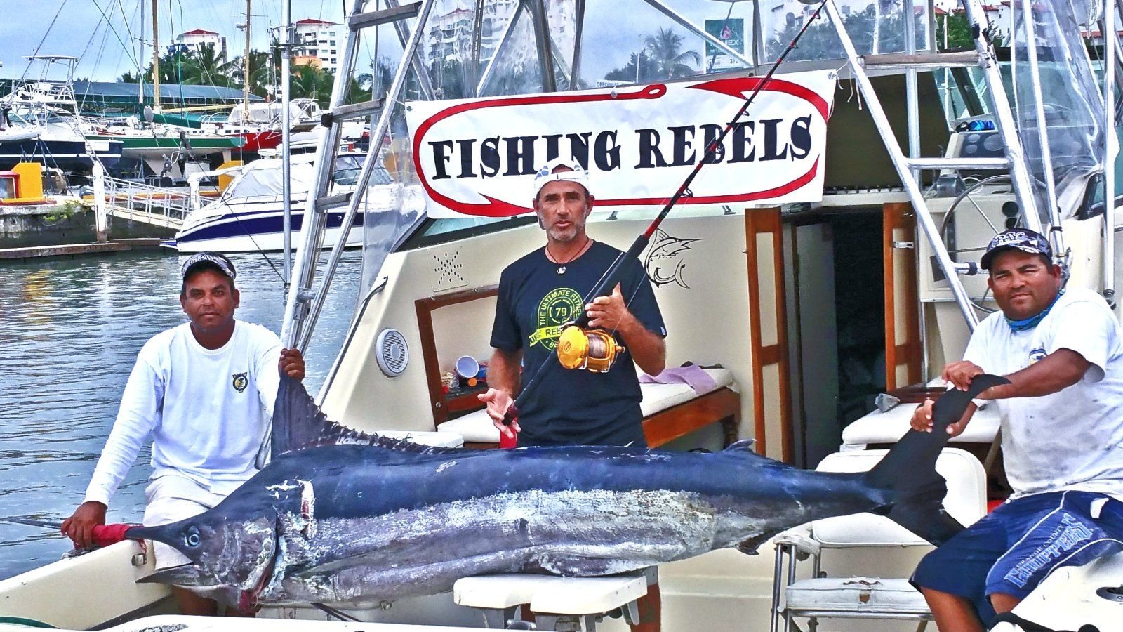 Fishing charter in Puerto Vallarta — crew with a marlin on the Fishing Rebels sportfisher at the marina